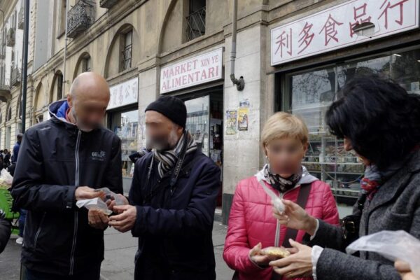 Tourists touch ethnic objects that the guide distributes among participants